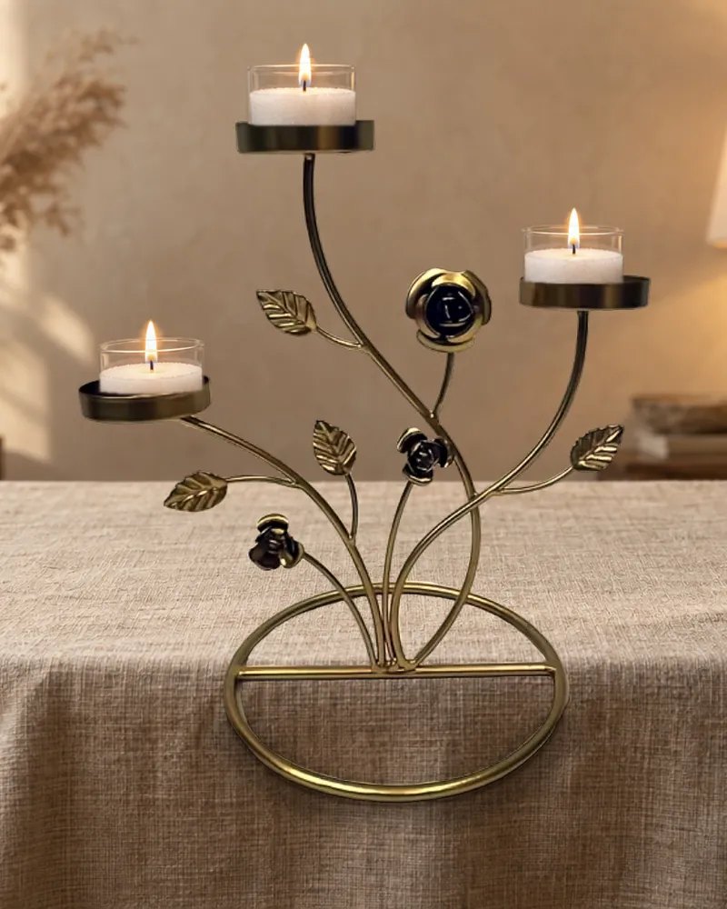 A gold rose-branch candle stand holding three glass candles
